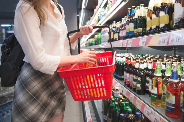 Vrouw Met Een Rode Mand Koopt Een Biertje Een Supermarkt — Stockfoto