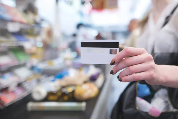 Mano Con Una Carta Credito Bianca Sullo Sfondo Una Cassa — Foto Stock