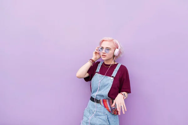 Стильная Девушка Хиппи Розовыми Волосами Стоит Фоне Фиолетовой Стены Слушает — стоковое фото