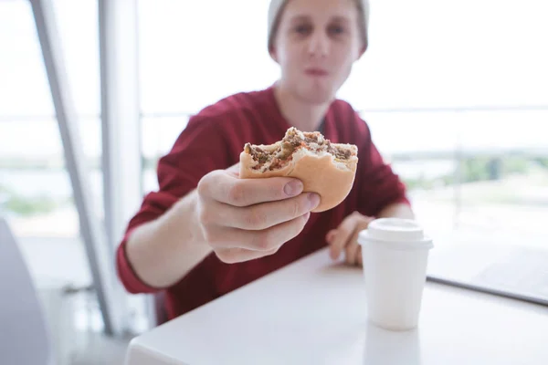 Der Junge Mann Sitzt Einem Hellen Fast Food Restaurant Und — Stockfoto