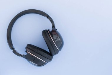 Kablosuz kulaklık mavi bir arka plan üzerinde üstten görünüm yalıtılır. Müzik konsepti. Boşaltmak