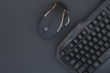 Black mouse, keyboard isolated on a dark background, top view. Flat lay gamer background. Workspace with a keyboard and mouse on a black background. Copyspace clipart