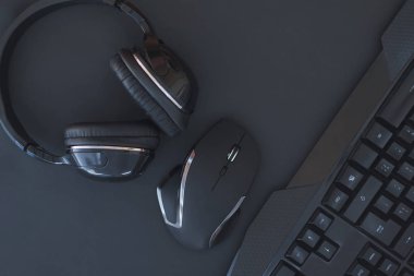 Siyah fare, klavye, kulaklık üstten görünüm, karanlık bir arka plan yalıtılır. Düz yatıyordu oyun arka plan. Çalışma alanı klavye, fare ve kulaklık siyah bir arka plan ile. Boşaltmak