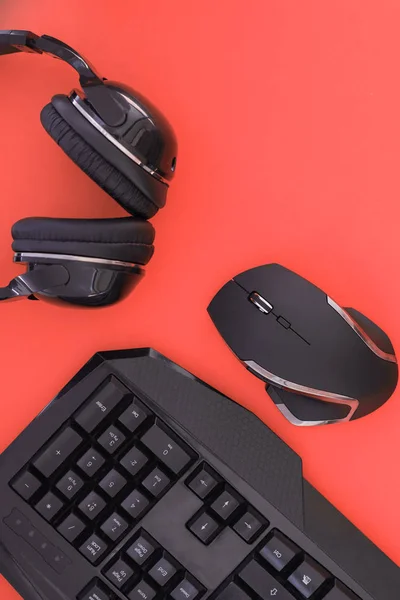 黒マウス キーボード ヘッドフォンが赤い背景 平面図上に孤立しています フラット横たわっていたゲーマーの背景 キーボード マウス 赤い背景の上にヘッドフォンに職場 Copyspace — ストック写真