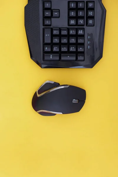 黄色の背景にマウスとキーボードのワークスペースです Copyspace 黒マウス キーボードの黄色の背景は 平面図上で分離します フラット横たわっていたゲーマーの背景 Copyspace — ストック写真