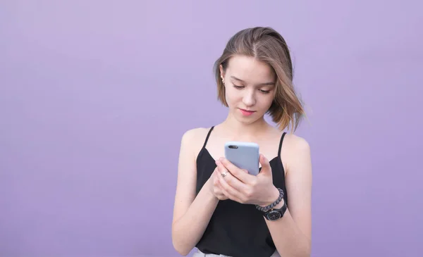 Chica Atractiva Utiliza Teléfono Inteligente Sobre Fondo Color Púrpura Pastel — Foto de Stock