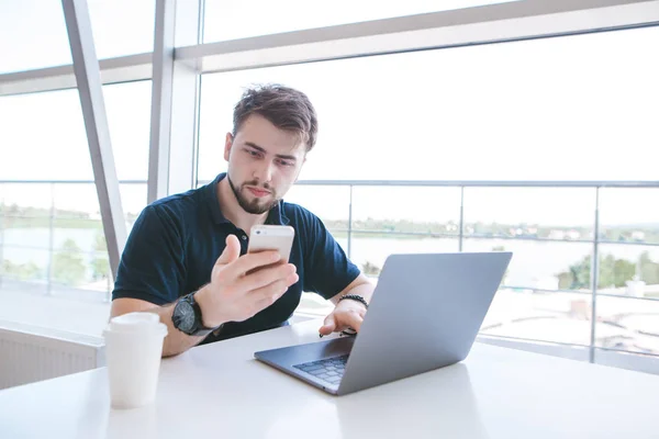 Vonzó Férfi Egy Asztalnál Egy Laptop Egy Pohár Kávét Használja — Stock Fotó