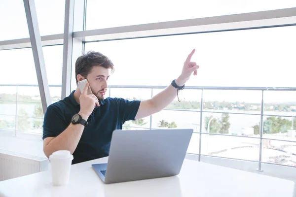 Hombre Serio Sienta Mesa Con Una Ventana Panorámica Blanca Con —  Fotos de Stock