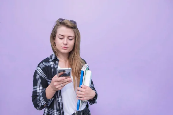 Menina Séria Vestindo Uma Roupa Casual Usa Smartphone Mantém Cadernos — Fotografia de Stock