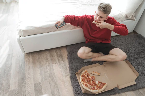 Jovem Sentado Chão Uma Sala Com Uma Caixa Pizza Trocando — Fotografia de Stock