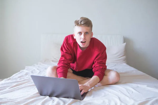 Portrait Surprised Young Man Sitting Bed Bright Room Laptop Looking — Stock Photo, Image