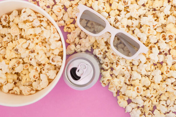3d glasses, a paper cup of popcorn and a drink in a metal jar are isolated on a pastel pink background. Flat lay. Copyspace. Cinema Concept. Background.