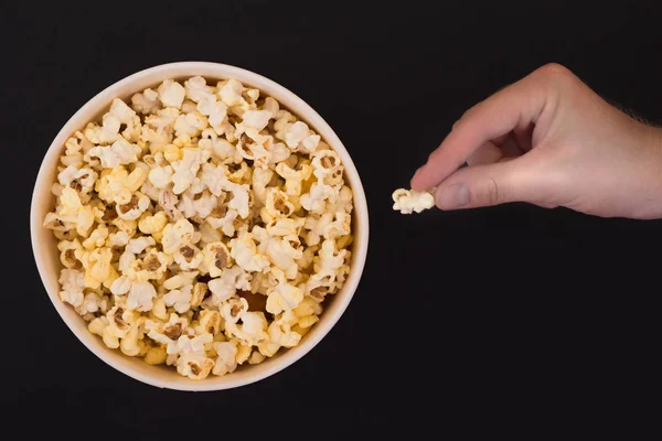 Männliche Hand Nimmt Ein Popcorn Aus Einem Pappbecher Auf Schwarzem — Stockfoto