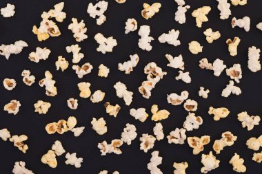 Arka plan. Pastel siyah arka plan, üstten görünüm üzerinde patlamış mısır. Sinema kavramı. Düz yatıyordu. Sinema kavramı.