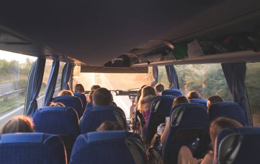 Turistik Tur otobüste. İnsanlar otobüs. Gün batımı, insanlarla büyük turist otobüsü salonu