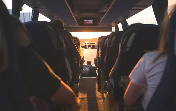 İnsanlar gün batımında otobüsle. Salon otobüs turist. Gün batımında turist otobüs iç seçici odak.
