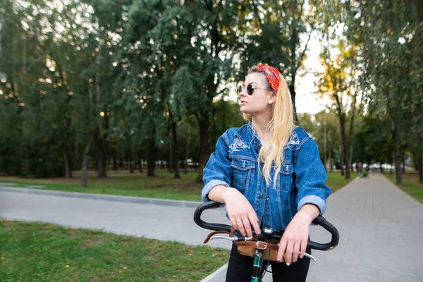 Stilvolle Frau Mit Sonnenbrille Und Jeansjacke Steht Mit Fahrrad Park — Stockfoto