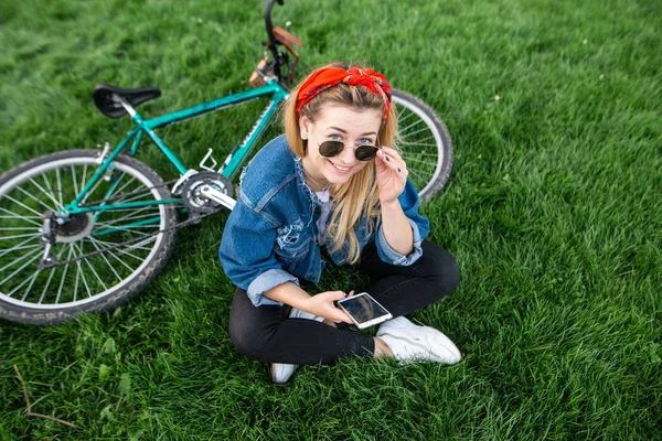 Güzel Bir Kız Ile Bir Bisiklet Yeşil Çim Üzerinde Oturan — Stok fotoğraf