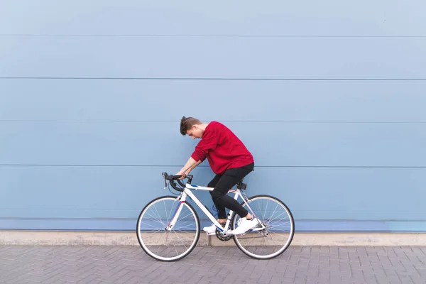 Jovem Montando Uma Estrada Branca Fundo Uma Parede Azul Elegante — Fotografia de Stock