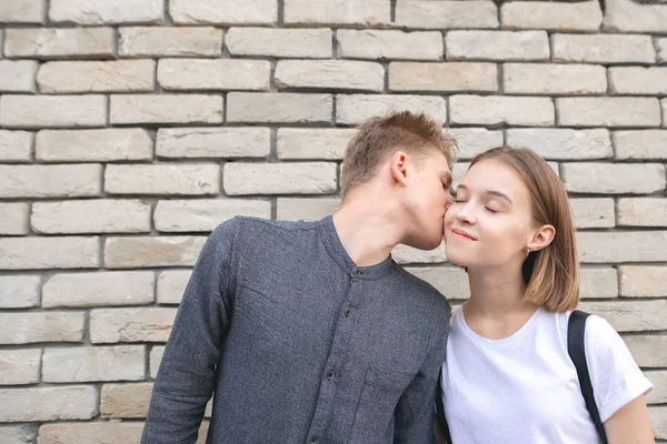 Feliz Casal Sorridente Contra Fundo Uma Parede Tijolos Jovem Beija — Fotografia de Stock