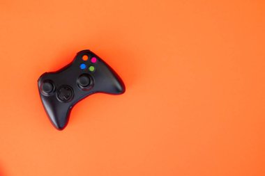 Siyah gamepad denetleyicisinin kırmızı bir arka plan üzerinde. Bilgisayar oyun rekabet. Oyun kavramı. Oyunun kablosuz kontrolü.
