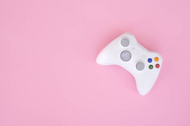 Beyaz gamepad denetleyicisi pastel pembe bir arka plan üzerinde. Beyaz oyun çubuğu bir pembe izole. Video oyunu yarışması. Oyun kavramı. Oyunun kablosuz kontrolü.
