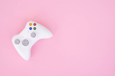 Beyaz gamepad denetleyicisi pastel pembe bir arka plan üzerinde. Beyaz oyun çubuğu bir pembe izole. Video oyunları Yarışması. Oyun kavramı. Boşaltmak. Flatlay