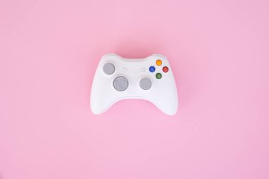 Beyaz gamepad denetleyicisi pastel pembe bir arka plan üzerinde. Beyaz oyun çubuğu bir pembe izole. Video oyunları Yarışması. Oyun kavramı. Boşaltmak. Flatlay