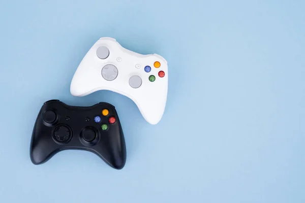 两个操纵杆 黑色和白色在一个柔和的蓝色背景 白色和黑色手柄在柔和的蓝色背景下隔离 游戏竞争 玩家概念 Copyspace — 图库照片