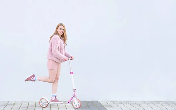 Счастливая Модная Девушка Розовой Одежде Едет Розовом Мотороллере Смотрит Камеру — стоковое фото