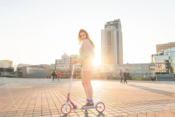 Pembe Elbise Sevimli Kız Öğrenci Ile Günbatımında Bir Tekme Scooter — Stok fotoğraf