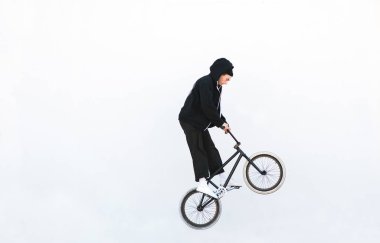 Bmx sürücüsü ile bir bisiklet üzerinde beyaz bir arka plan atlama. Binici beyaz arka plan üzerinde izole bmx atla. Boşaltmak. BMX kavramı