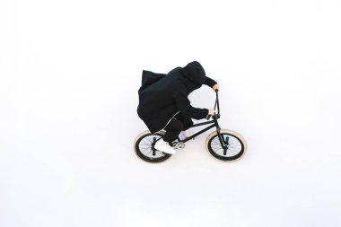 BMX sürücüsü bir bisiklet ile beyaz duvara gidiyor. Genç adam Bmx. Bmx freestyle üzerinde hile yapıyor