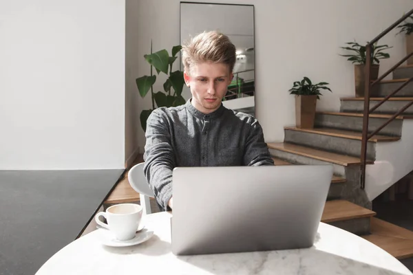 Joven Estudiante Serio Sienta Acogedor Café Usa Una Computadora Portátil —  Fotos de Stock