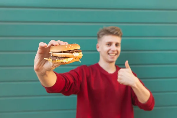 Mosolygó Ember Egy Étvágygerjesztő Burger Tart Kezében Mutat Egy Remek — Stock Fotó