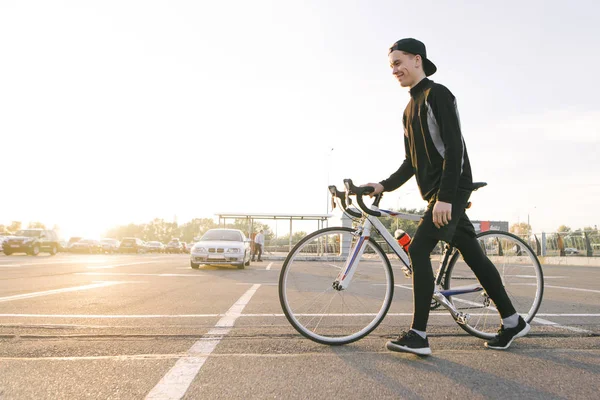 Jovem Feliz Roupas Esportivas Escuras Boné Puxa Uma Bicicleta Rua — Fotografia de Stock