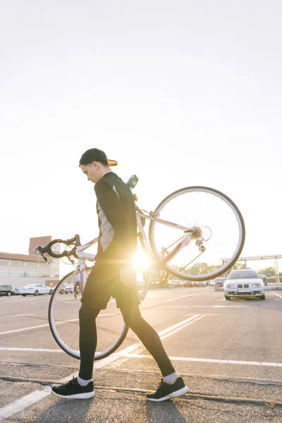 Jovem Ciclista Sportswear Escuro Carregando Uma Bicicleta Estrada Seus Ombros — Fotografia de Stock