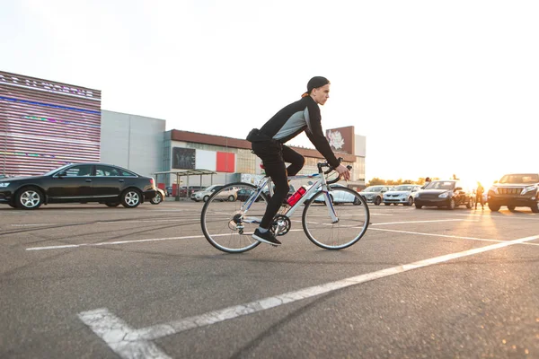 Jovem Cavaleiro Monta Uma Bicicleta Cidade Fundo Pôr Sol Olha — Fotografia de Stock