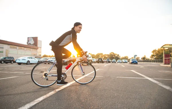 Jovem Cavaleiro Monta Uma Bicicleta Cidade Fundo Pôr Sol Olha — Fotografia de Stock