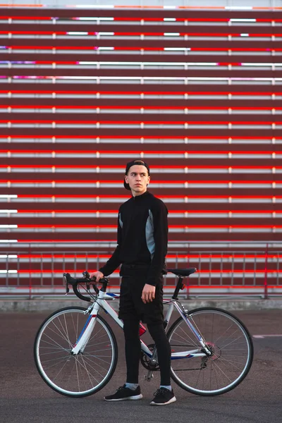 Joven Con Una Bicicleta Vestido Atlético Está Sobre Fondo Rojo — Foto de Stock