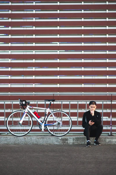 Jovem Esporte Escuro Usa Uma Bicicleta Fundo Bordô Listrado Usa — Fotografia de Stock