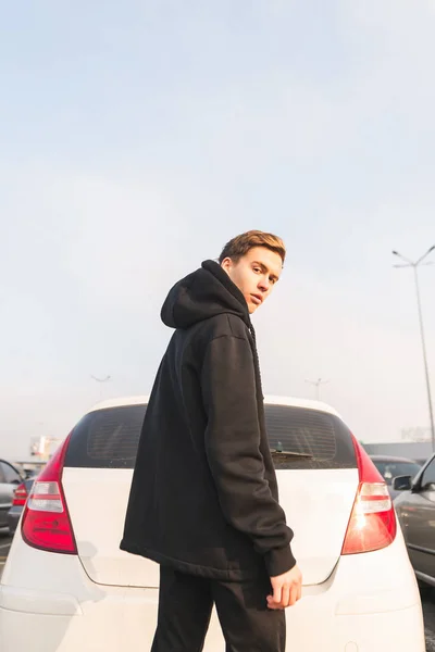 Jonge Man Een Zwart Hoodie Staat Door Auto Camera Met — Stockfoto