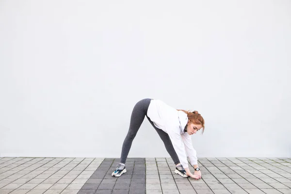 Spor Giyim Giyen Genç Kız Uzanır Stretchings Beyaz Bir Duvar — Stok fotoğraf