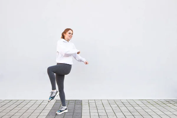 Arka Plan Beyaz Bir Duvar Isınma Yapıyor Bir Atletik Kız — Stok fotoğraf