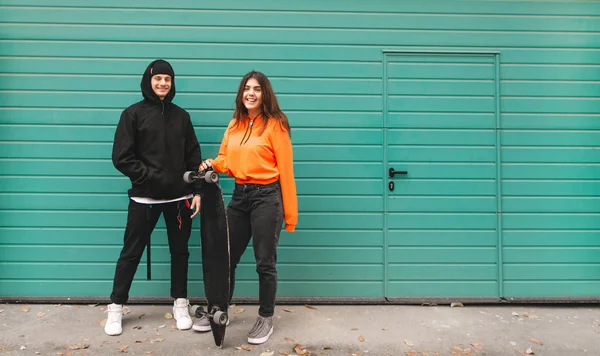 Sorrindo Jovem Casal Pessoas Elegantes Roupas Rua Suporte Longboard Contra — Fotografia de Stock