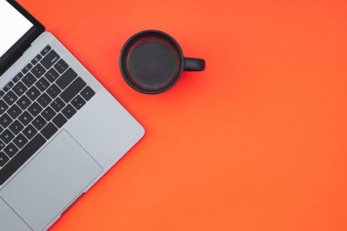 Gri modern defter ve içki bardakta kırmızı bir arka plan, üstten görünüm. Boşaltmak. Düz yatıyordu