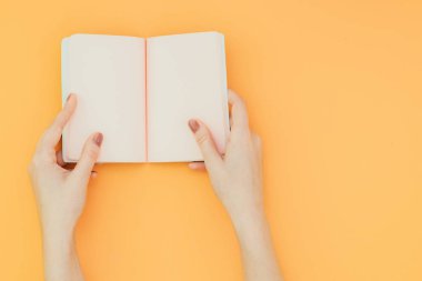 Eller turuncu bir arka plan bir görünüm yukarıdan açık bir defter bekle. Boşaltmak