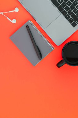 Modern dizüstü, beyaz kulaklık, gri defter ile bir kalem ve bir fincan kahve kırmızı arka plan ve metin, yukarıdan bir görünüm için bir yer. Flatlay boşaltmak.