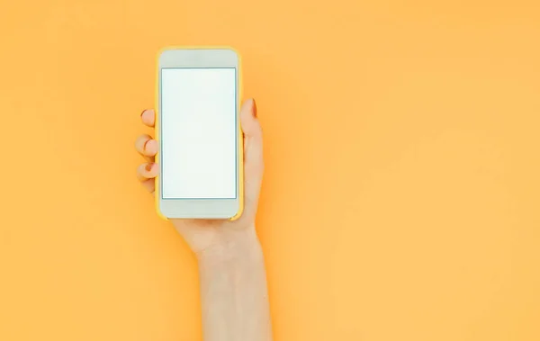 Mujer Sostiene Teléfono Inteligente Con Una Pantalla Blanca Fondo Naranja — Foto de Stock