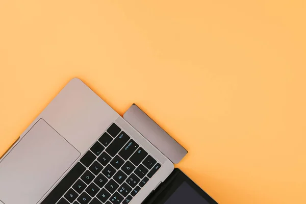 Modern laptop with USB Type-C adapter on orange background. Technology concept. Flat lay